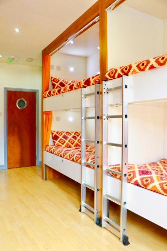 a bedroom with three bunk beds in a room at The Liverpool Pod Travel Hostel in Liverpool