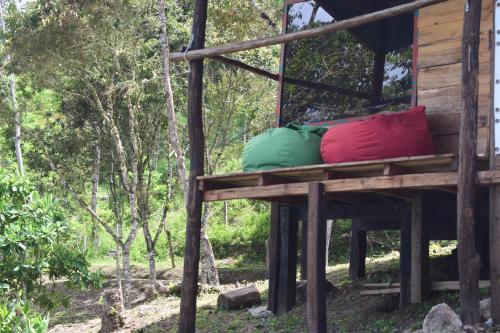 two colorful pillows sitting on a porch of a cabin at Monte La MaMa Ecolodge in Viotá