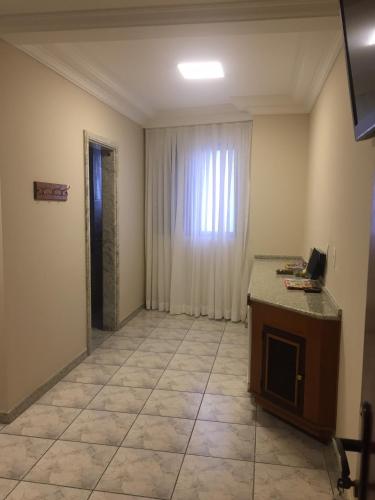 a room with a table and a window and a door at Hotel Diamante in Sao Paulo
