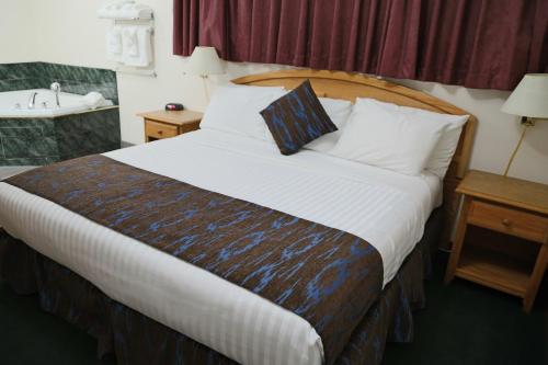 a hotel room with a large bed and a sink at Slumber Lodge in Penticton