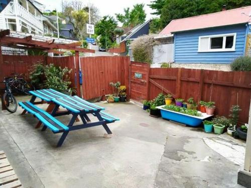 a picnic table in a backyard with a fence at Crashpalace Napier in Napier