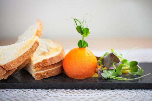 a plate with bread and an orange and a salad at Millennium Hotel New Plymouth, Waterfront in New Plymouth