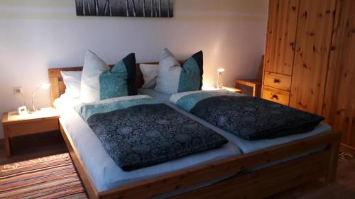 a bedroom with a large bed with two pillows at Ferienwohnungen Rump in Hilchenbach