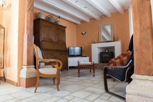 - un salon avec des chaises, une télévision et un canapé dans l'établissement Les Ruchers d'Emile, à Landécourt