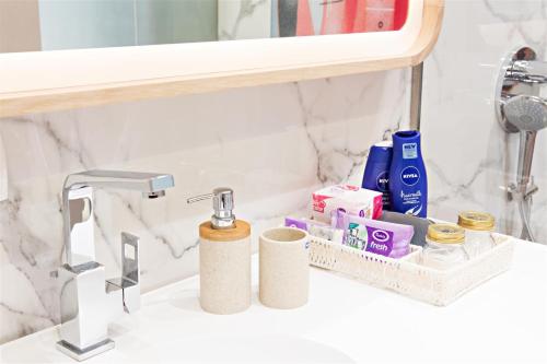 a bathroom sink with toiletries on a counter at FERHADIJA Apartments by Nejra in Sarajevo