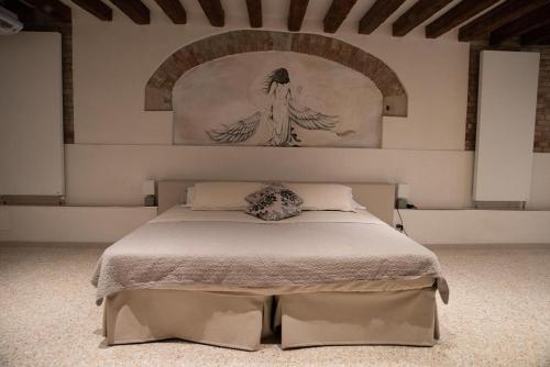 una camera da letto con un letto e un dipinto sul muro di Casa Marco Polo a Venezia