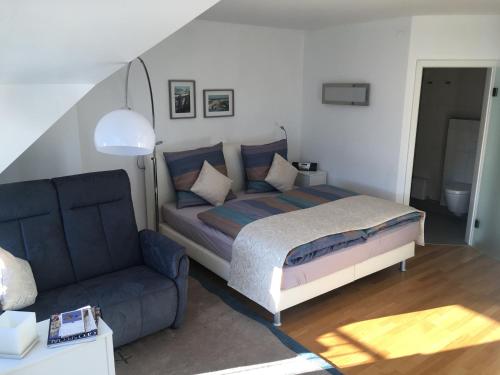 a bedroom with a bed and a couch at Gästehaus Weingut Meierer in Kesten