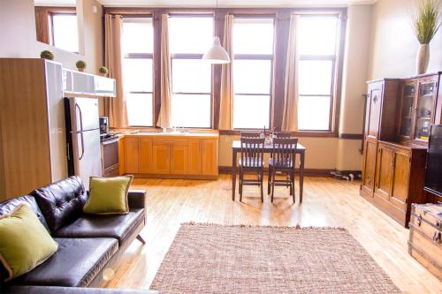 a living room with a couch and a table and chairs at School 31 Lofts in Rochester