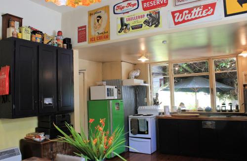 cocina con armarios negros y nevera verde en Chester St Backpackers en Christchurch