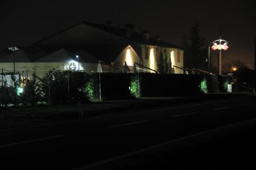 a house lit up at night with a fence at SPIEDO IMPERIALE - Locanda e Ristorante in Cotignola