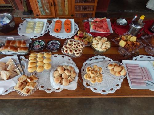 een tafel met veel verschillende soorten voedsel erop bij Pousada Verde Villas in Brumadinho