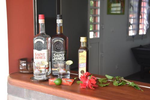 three bottles of whiskey sitting on a table at Haut de villa dans son écrin de verdure in Sainte-Marie