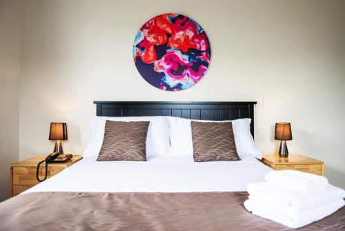 a bedroom with a large bed with two lamps at 123 Motel in Christchurch