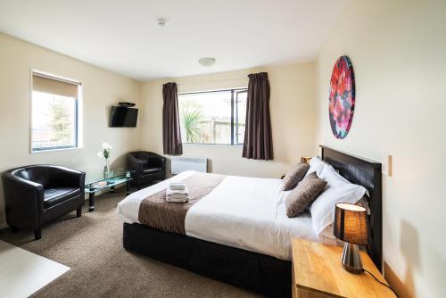 a hotel room with a bed and a desk at 123 Motel in Christchurch