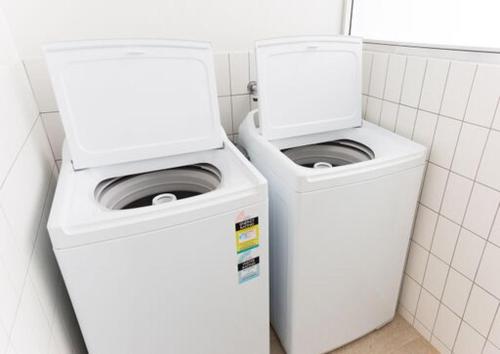 two washing machines sitting next to each other in a bathroom at Shoreline Hotel in Hobart