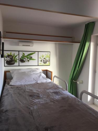 a bedroom with a bed with a green curtain at Appartement à Cap Estérel Village Pierre et Vacances Piscines et parking inclus in Agay - Saint Raphael