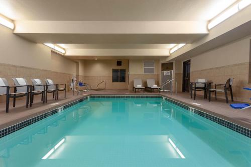a large swimming pool with chairs and a table at Wingate by Wyndham Moses Lake in Moses Lake