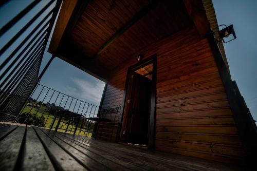 a wooden cabin with a door on a deck at Cabañas Valle de los Ciervos in Tandil