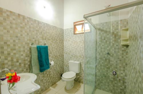 a bathroom with a toilet and a glass shower at Casa da Pipoca in Morro de São Paulo