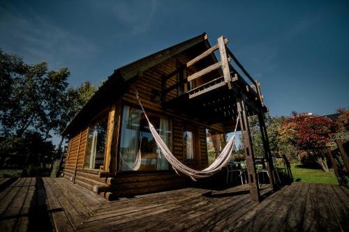 a log cabin with a hammock outside of it at Cabañas Valle de los Ciervos in Tandil