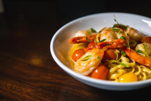a bowl of food with shrimp and pasta on a table at E Central Hotel Downtown Los Angeles in Los Angeles
