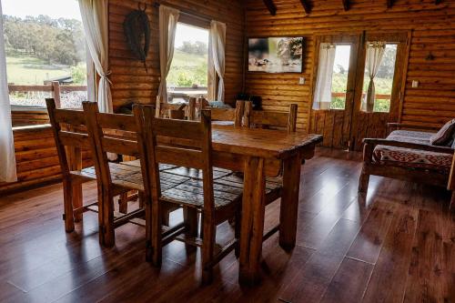 a dining room with a wooden table and chairs at Cabañas Valle de los Ciervos in Tandil