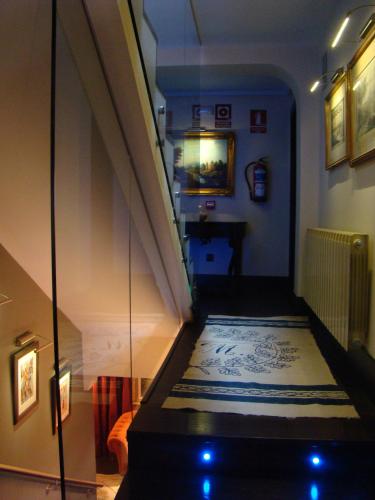 a hallway with a staircase with a blue and white carpet at Hotel-Hospedería los Templarios in Sepúlveda