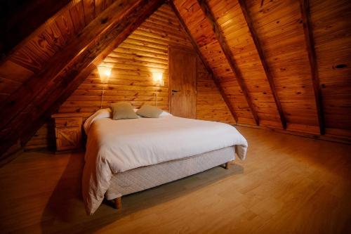 a bedroom with a bed in a wooden cabin at Cabañas Valle de los Ciervos in Tandil