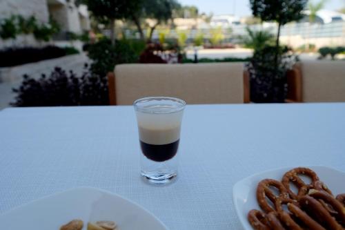 a drink on a table next to a plate of pretzels at Tantur Hills Hotel - Jerusalem in Jerusalem