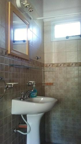 La salle de bains est pourvue d'un lavabo et d'un miroir. dans l'établissement Wilka Pacha - Casas Serranas, à Capilla del Monte