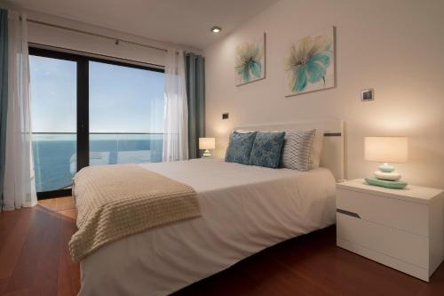ein Schlafzimmer mit einem großen Bett und einem großen Fenster in der Unterkunft Angel´s Paradise Luxury and Sophistication in Funchal