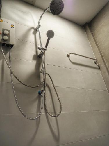 a shower in a bathroom with a microphone on the wall at Lotto House in Ko Samed