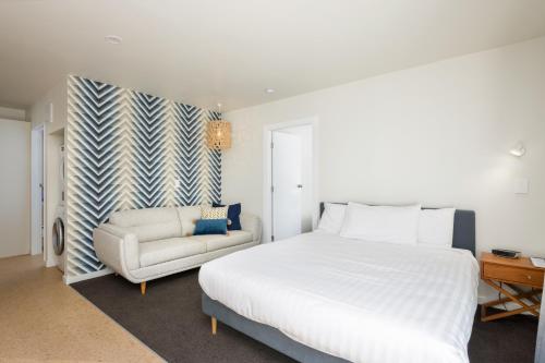 a bedroom with a large bed and a couch at The Adelphi in Christchurch
