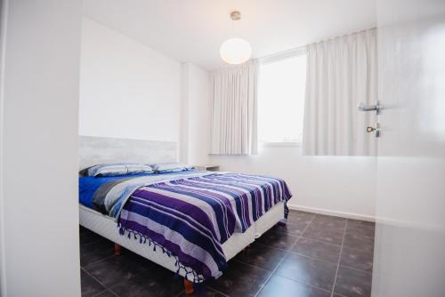 a white bedroom with a bed and a shower at Apart FJL in Río Cuarto