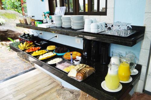 a buffet of food and drinks on a table at Pousada Guapuruvu in Abraão