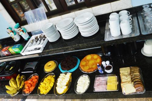 a buffet with plates and food on a table at Pousada Guapuruvu in Abraão