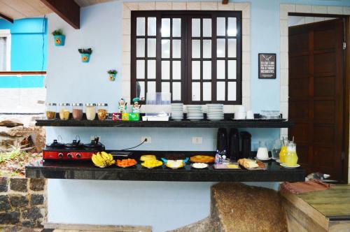 a buffet of food on a counter in a kitchen at Pousada Guapuruvu in Abraão