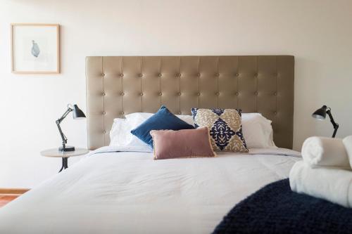 una camera da letto con un grande letto con cuscini sopra di Belma Boutique Bed and Breakfast a Lima