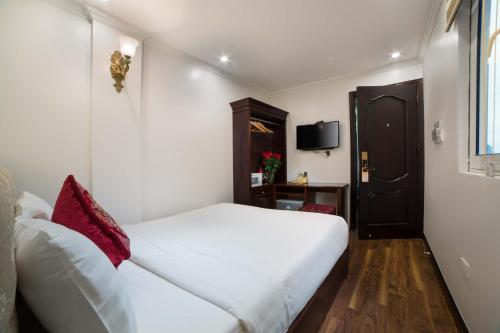 a hotel room with a white bed with red pillows at Golden Sail Hotel & Spa in Hanoi