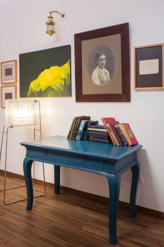 a blue table with books on it in a room with paintings at Belma Boutique Bed and Breakfast in Lima