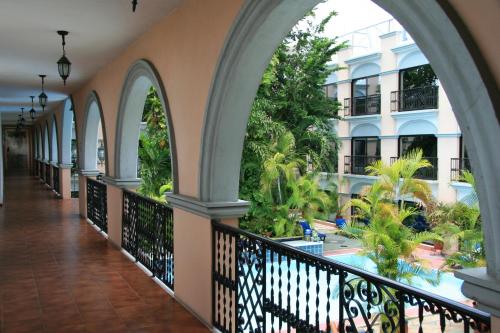 a corridor of a building with arches and a swimming pool at Hotel Doralba Inn in Mérida