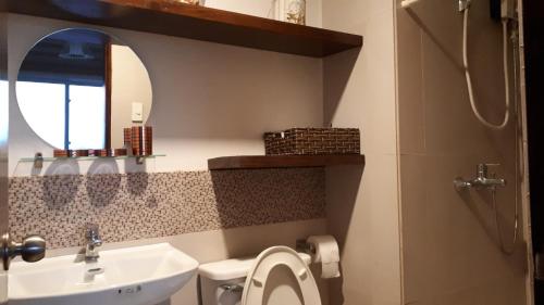 a bathroom with a sink and a toilet and a mirror at JRMPT Residence in Cebu City