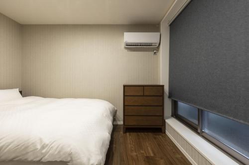 a bedroom with a bed and a air conditioner on the wall at Kyo no yado en in Kyoto
