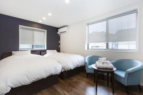 a bedroom with two beds and a table and chairs at Kyo no yado en in Kyoto