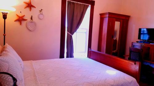 a bedroom with a large bed and a window at Captain's Inn at Moss Landing in Moss Landing