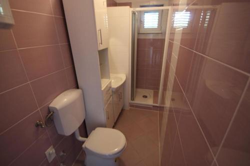a small bathroom with a toilet and a shower at Apartments Sonne in Crikvenica