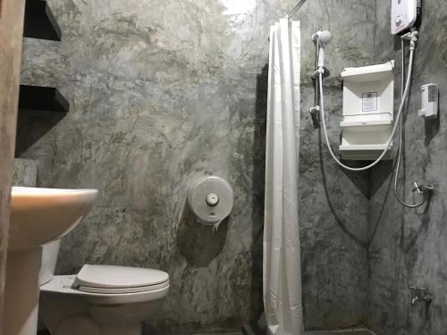 a bathroom with a shower and a toilet and a sink at Nornlamphun Boutique Hotel in Lamphun