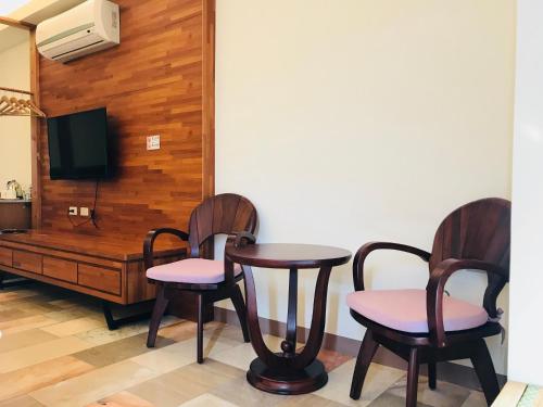 Pokój z dwoma krzesłami, stołem i telewizorem w obiekcie The third great-uncle's house w mieście Baihe