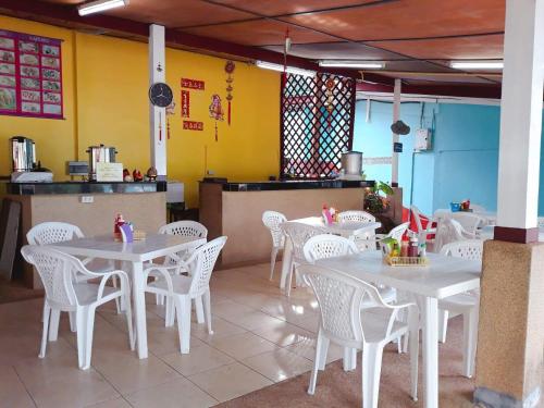 a dining room with white tables and white chairs at Phi Phi View Point Resort in Phi Phi Don