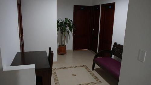 a room with a table and a chair and a plant at Hotel Sipa in Duitama